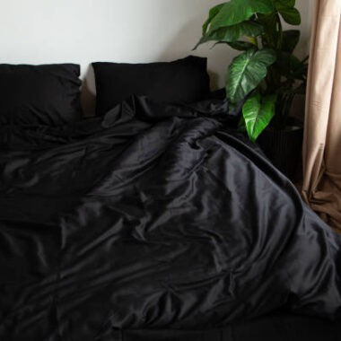 Black satin bed clothes white wall two pillow wooden window
